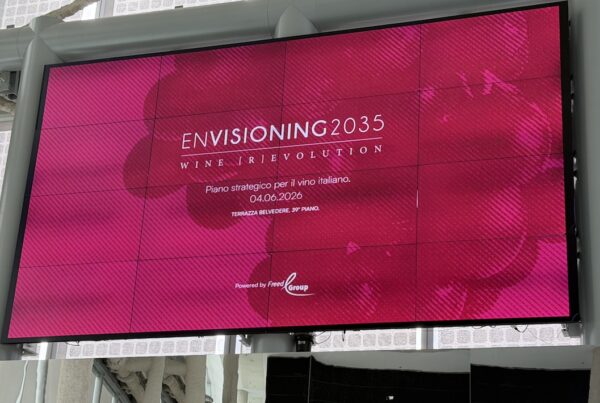 Maxischermo fucsia con il logo dell'evento Envisioning 2035 Wine Revolution alla Terrazza Belvedere di Palazzo Regione Lombardia.